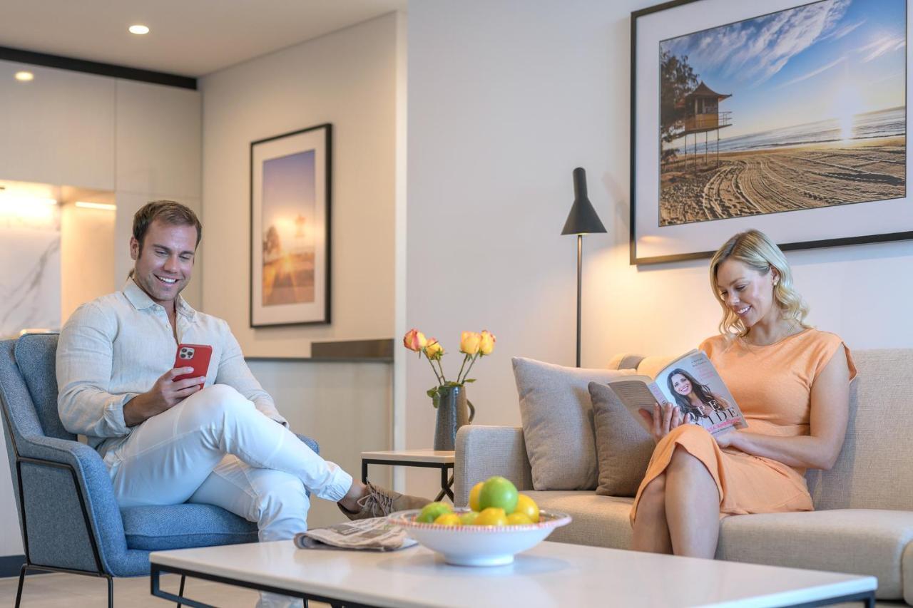 Meriton Suites Surfers Paradise Гоулд Коуст Екстериор снимка A couple reading a magazine in their living room
